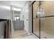 Bathroom featuring light wood floors, grey cabinets, a shower and a view of the Primary closet at 12753 Bristow Ln, Fishers, IN 46037