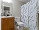 Bathroom featuring a wooden vanity, toilet, patterned shower curtain, and tile flooring at 12753 Bristow Ln, Fishers, IN 46037