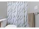 Clean bathroom featuring a decorative shower curtain, a neutral colored towel and white toilet at 12753 Bristow Ln, Fishers, IN 46037