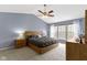 Vaulted ceiling bedroom with a wood bed frame, nightstands, dresser, ceiling fan and three windows at 12753 Bristow Ln, Fishers, IN 46037
