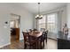 Bright dining area features a wood table, backyard views from the window, and contemporary light fixture at 12753 Bristow Ln, Fishers, IN 46037