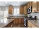 Well-lit kitchen featuring granite countertops, wood cabinets, and stainless steel appliances at 12753 Bristow Ln, Fishers, IN 46037