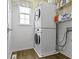 Bright laundry room features a stacked washer and dryer, wood-look flooring, and a window for natural light at 12753 Bristow Ln, Fishers, IN 46037