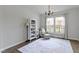 Bright living room showcasing large windows, an accent rug, and a cozy armchair with ottoman at 12753 Bristow Ln, Fishers, IN 46037