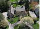 Overhead view of the home's manicured lawn, mature trees, brick walkway and circular driveway at 13599 Brentwood Ln, Carmel, IN 46033