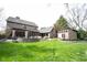 Expansive backyard with lush lawn, stone patio, built-in fire pit, and outdoor seating areas perfect for entertaining at 13599 Brentwood Ln, Carmel, IN 46033