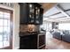 Elegant bar area features dark cabinetry, mosaic backsplash, and a built-in wine refrigerator at 13599 Brentwood Ln, Carmel, IN 46033