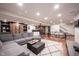 Finished basement features a large sectional sofa, a ping pong table, and bar at 13599 Brentwood Ln, Carmel, IN 46033
