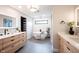 Modern bathroom with double vanity, sleek mirrors, freestanding tub, and stylish finishes at 13599 Brentwood Ln, Carmel, IN 46033