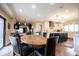 Open dining area with a wooden table and black chairs connecting to the kitchen at 13599 Brentwood Ln, Carmel, IN 46033