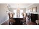 Spacious dining room featuring a large table, hardwood floors, and elegant chandelier lighting at 13599 Brentwood Ln, Carmel, IN 46033