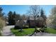 Stunning two-story home with red shutters, mature trees, and a circular driveway at 13599 Brentwood Ln, Carmel, IN 46033