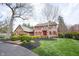 Beautiful two-story home with red shutters, lush landscaping and a circular driveway at 13599 Brentwood Ln, Carmel, IN 46033