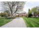 Charming two-story home with mature trees, well-maintained lawn, and circular driveway at 13599 Brentwood Ln, Carmel, IN 46033