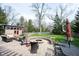 Beautifully designed backyard with a brick patio, comfortable seating, a fire pit, and lush landscaping at 13599 Brentwood Ln, Carmel, IN 46033