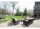 Inviting patio area with outdoor seating, lush green lawn, mature trees, and a charming garden at 13599 Brentwood Ln, Carmel, IN 46033