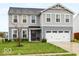 Two-story home with gray siding, a two-car garage, and a small front yard at 13820 N Cardonia Dr, Camby, IN 46113