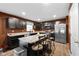 Kitchen features dark cabinets, stainless steel appliances, an island with bar seating, and wood-look flooring at 13820 N Cardonia Dr, Camby, IN 46113