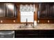 Beautifully appointed kitchen sink with stainless steel appliances, dark wood cabinets, and granite countertops at 13820 N Cardonia Dr, Camby, IN 46113