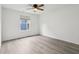 Neutral bedroom featuring wood-look flooring, a ceiling fan, and a bright window at 13847 Wabash Dr, Fishers, IN 46038