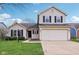 Charming two-story home featuring a two car garage, well maintained lawn and dark shutters against neutral siding at 13847 Wabash Dr, Fishers, IN 46038