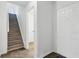 Hallway leading to carpeted stairs featuring stone flooring and white trim and doors at 13847 Wabash Dr, Fishers, IN 46038