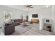 Bright living room with gray sofa, ceiling fan, TV and wood-look flooring at 13847 Wabash Dr, Fishers, IN 46038