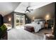 Cozy bedroom features dark walls, a king-sized bed, balcony access, and neutral-toned carpet at 1403 Fletcher Ave, Indianapolis, IN 46203
