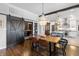 Dining area featuring a rustic wooden table, chandelier, and a modern barn door leading to other rooms at 1403 Fletcher Ave, Indianapolis, IN 46203