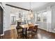 Elegant dining room with modern chandelier, hardwood floors, and adjacent gourmet kitchen at 1403 Fletcher Ave, Indianapolis, IN 46203