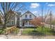 Charming two-story home featuring a landscaped front yard with mature trees and an inviting front porch at 1403 Fletcher Ave, Indianapolis, IN 46203