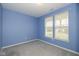 Bright bedroom with a large window, gray carpet, and soft blue walls at 1468 Lexington Trl, Greenfield, IN 46140