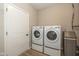 Bright laundry area featuring modern front-load washer and dryer set, plus a water filtration system at 1468 Lexington Trl, Greenfield, IN 46140