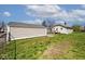 Large backyard with green grass, a charming house, and a detached garage at 1511 E Tabor St, Indianapolis, IN 46203