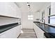 Modern kitchen with white cabinets, dark countertops, and stainless steel appliances at 1511 E Tabor St, Indianapolis, IN 46203