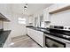Modern kitchen featuring white cabinets, stainless steel appliances and hardwood-style floors at 1511 E Tabor St, Indianapolis, IN 46203