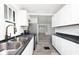 Bright modern kitchen with stainless steel appliances, dark countertops, and wood-style flooring at 1511 E Tabor St, Indianapolis, IN 46203