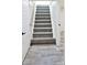 Carpeted stairway, door to the left and luxury vinyl plank flooring at 1511 E Tabor St, Indianapolis, IN 46203