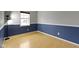 Bedroom with half blue wall, hardwood floors, window and a modern lamp at 1517 Citation N Cir, Lebanon, IN 46052