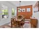 Bright dining room with large windows, wood table, stylish lighting, and warm accent wall at 16422 Brigham Ln, Westfield, IN 46074