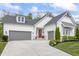 Charming home with a two-car garage, red door, and a beautifully landscaped front yard at 16422 Brigham Ln, Westfield, IN 46074