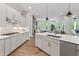 Bright kitchen featuring white cabinets, a large island, and stainless steel appliances, open to the living room at 16422 Brigham Ln, Westfield, IN 46074