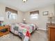 Comfortable bedroom showcasing a cozy quilt bedspread, complemented by two windows and a dresser at 1734 Bittersweet Dr, Anderson, IN 46011
