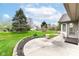 Backyard with a patio, lush green lawn, flower bed, and mature trees for peaceful outdoor living at 18009 Sun Ridge Cir, Noblesville, IN 46062