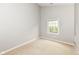 An empty bedroom with a neutral carpet, light gray walls, and a window with natural light at 18009 Sun Ridge Cir, Noblesville, IN 46062