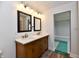 Bathroom featuring a vanity with double sinks, quartz countertops, and a view of the bedroom at 1934 N Arlington Ave, Indianapolis, IN 46218