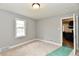 Cozy bedroom features neutral carpet, grey walls, white trim, and a doorway leading to the kitchen at 1934 N Arlington Ave, Indianapolis, IN 46218
