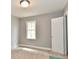 Bedroom with neutral carpet, grey walls, white trim, and a bright window at 1934 N Arlington Ave, Indianapolis, IN 46218