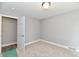 Bright bedroom boasts neutral carpet, grey walls, white trim, a door leading to a hallway or another room at 1934 N Arlington Ave, Indianapolis, IN 46218