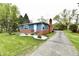 Lovely home exterior features a well-manicured lawn, brick and blue siding, and a long driveway at 1934 N Arlington Ave, Indianapolis, IN 46218